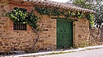 Jakobsweg (Camino Francés): Traditionelles Haus mit Holztür und rankendem Wein - El Ganso